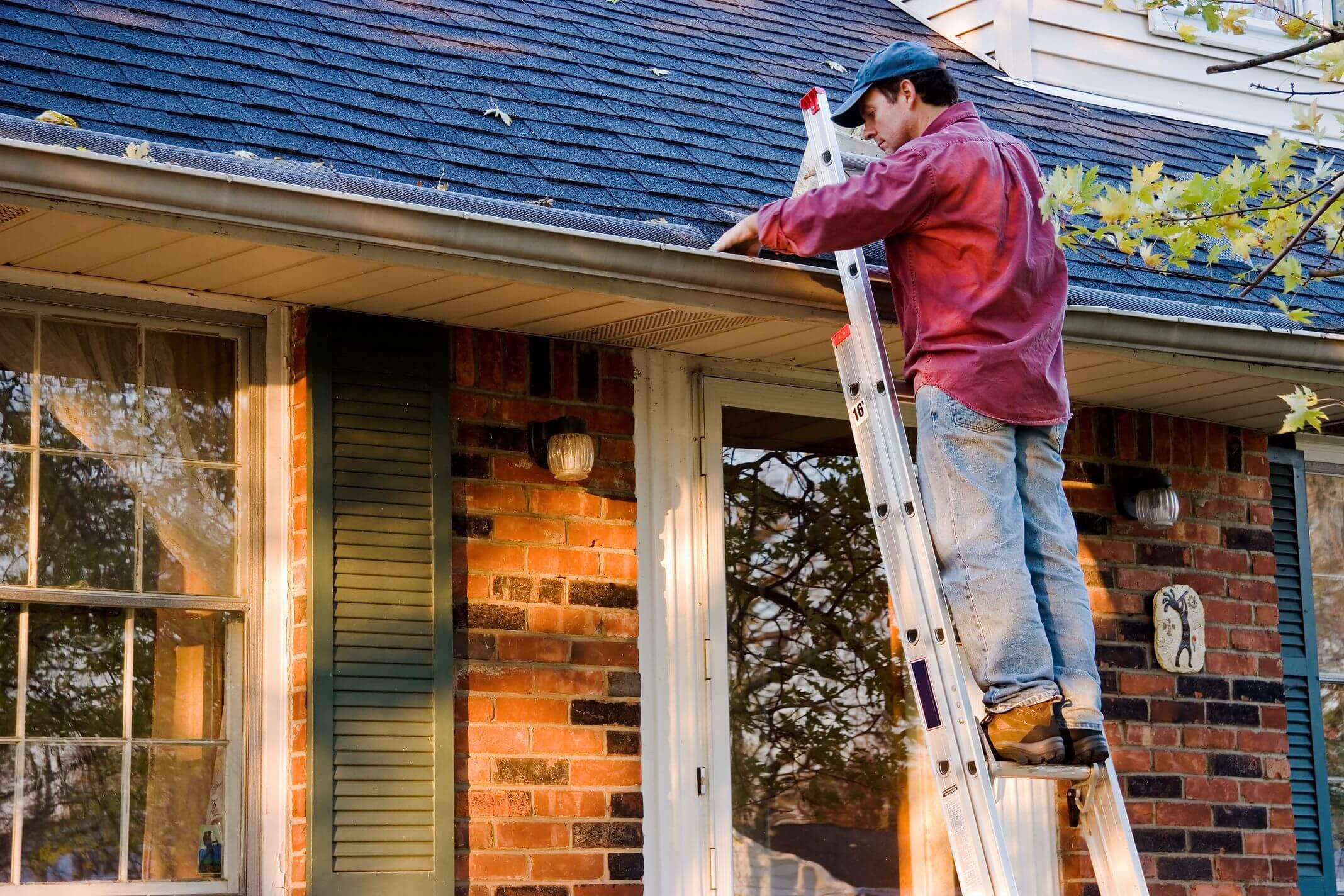 Commercial gutter cleaning clearing debris from a building roofline